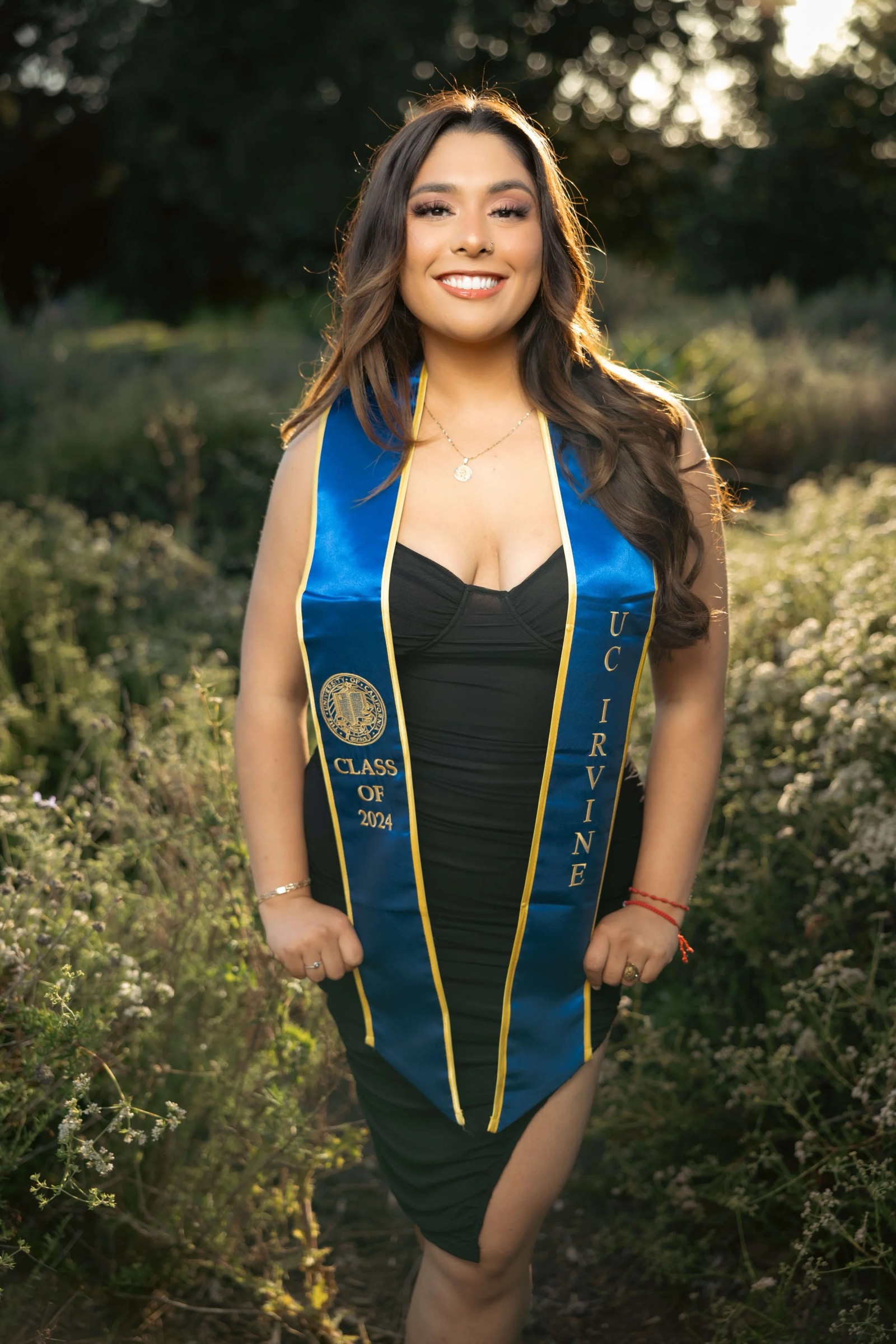 UCI graduate posing with Aldrich Park flowers