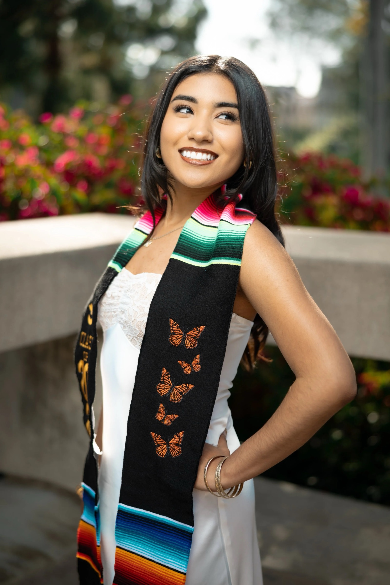 UCI graduate posing in Aldrich Park red flower area