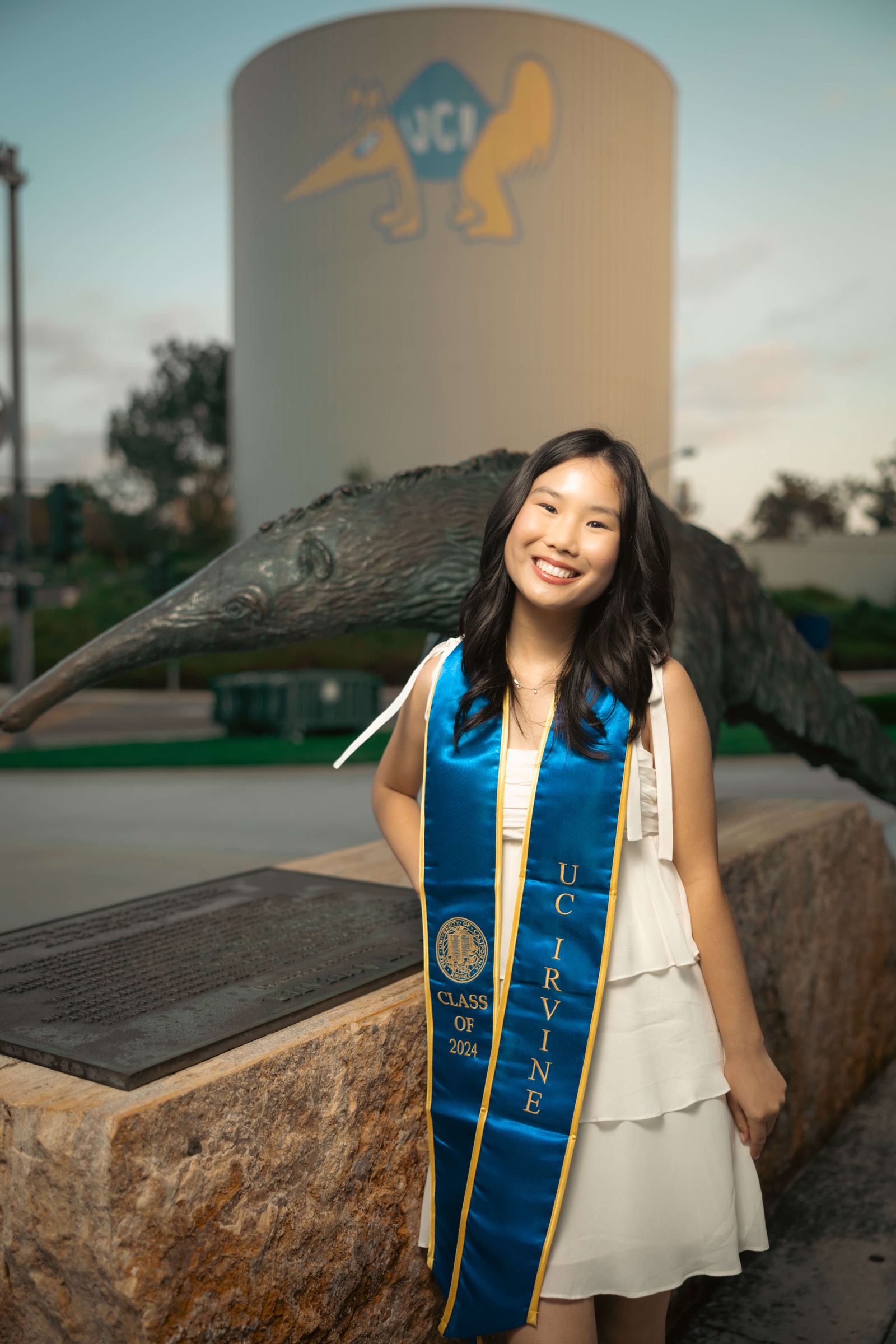 UCI graduate at anteater statue and water tower