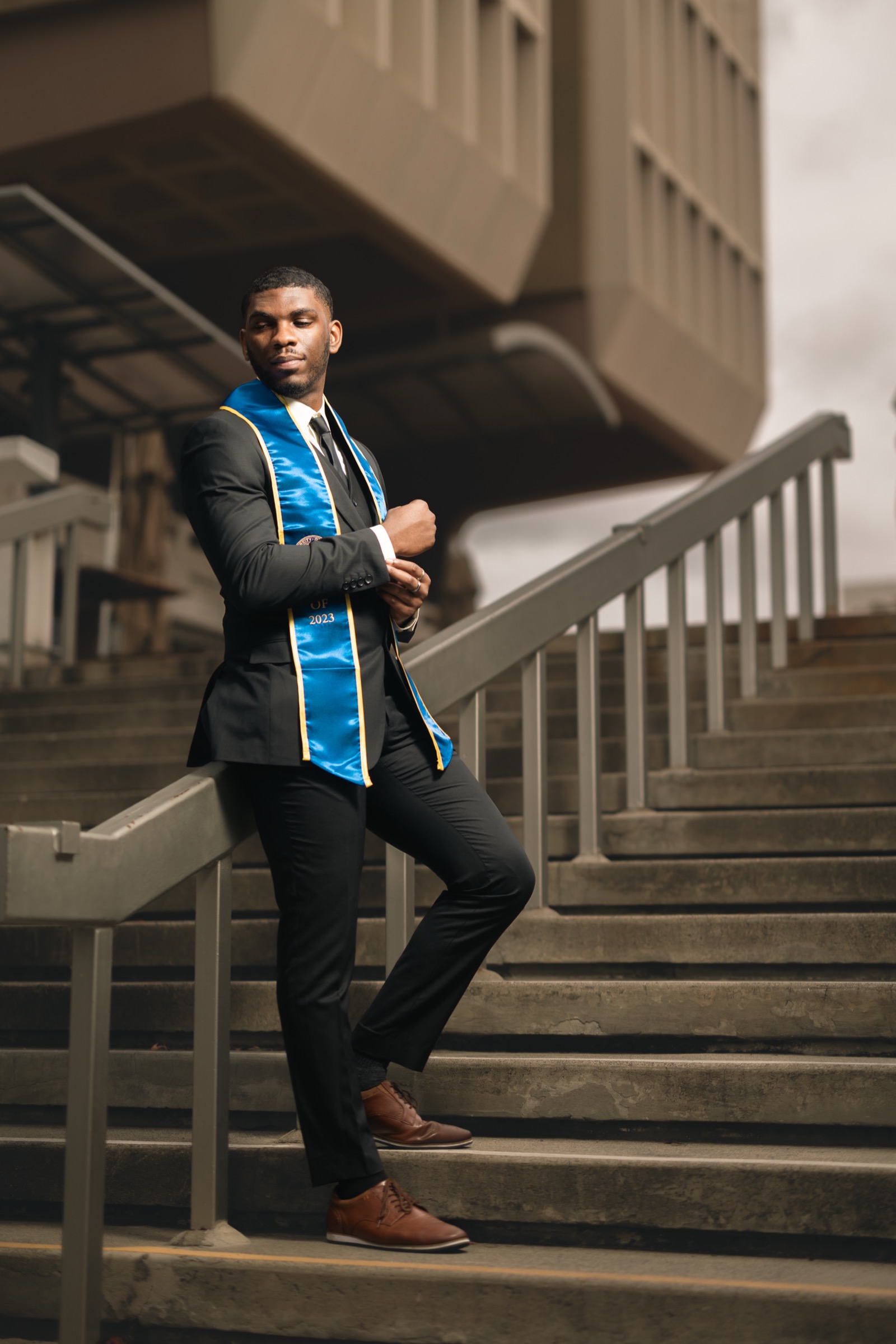 UCI graduate in suit with sash