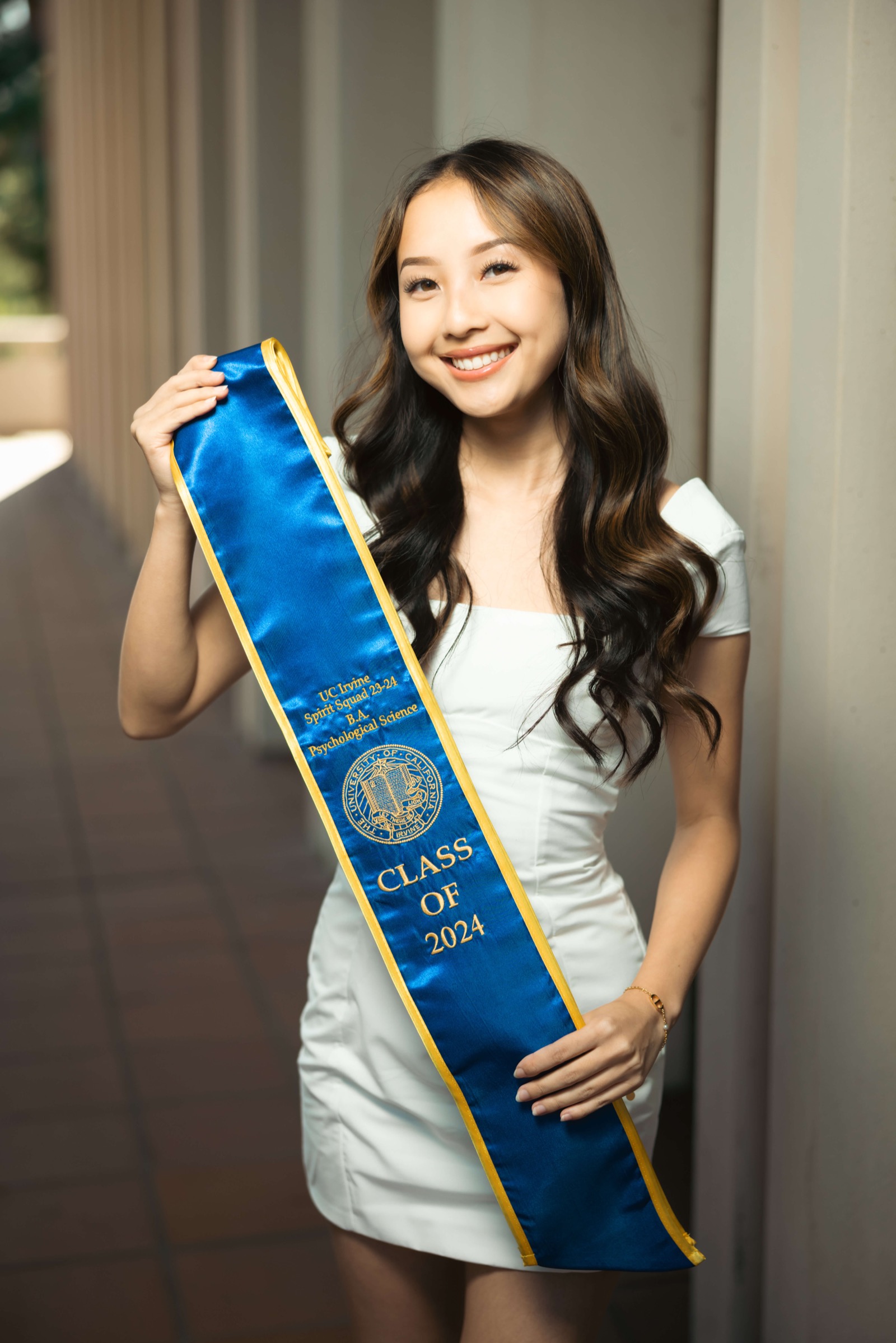 UCI graduate holding sash showing Class of 2024 details